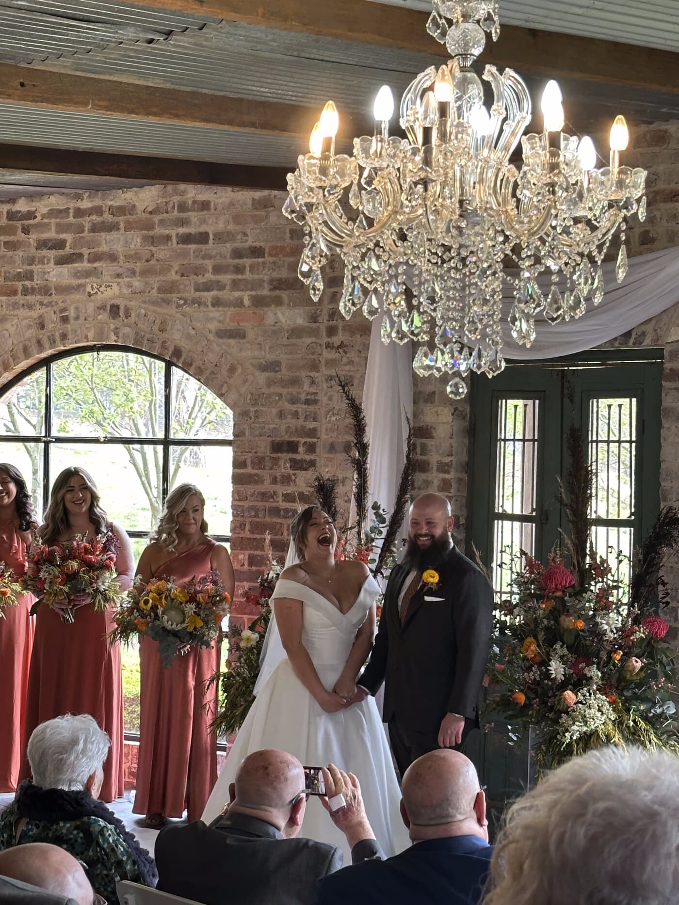 Damiano & Elaine at their ceremony inside the Mali Brae Farm barn, beneath the crystal chandelier